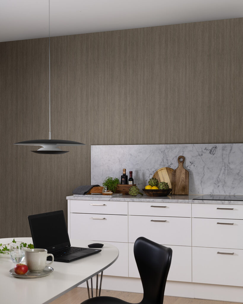 Wallpaper with a wood pattern in a kitchen with white cabinet doors and a marble countertop