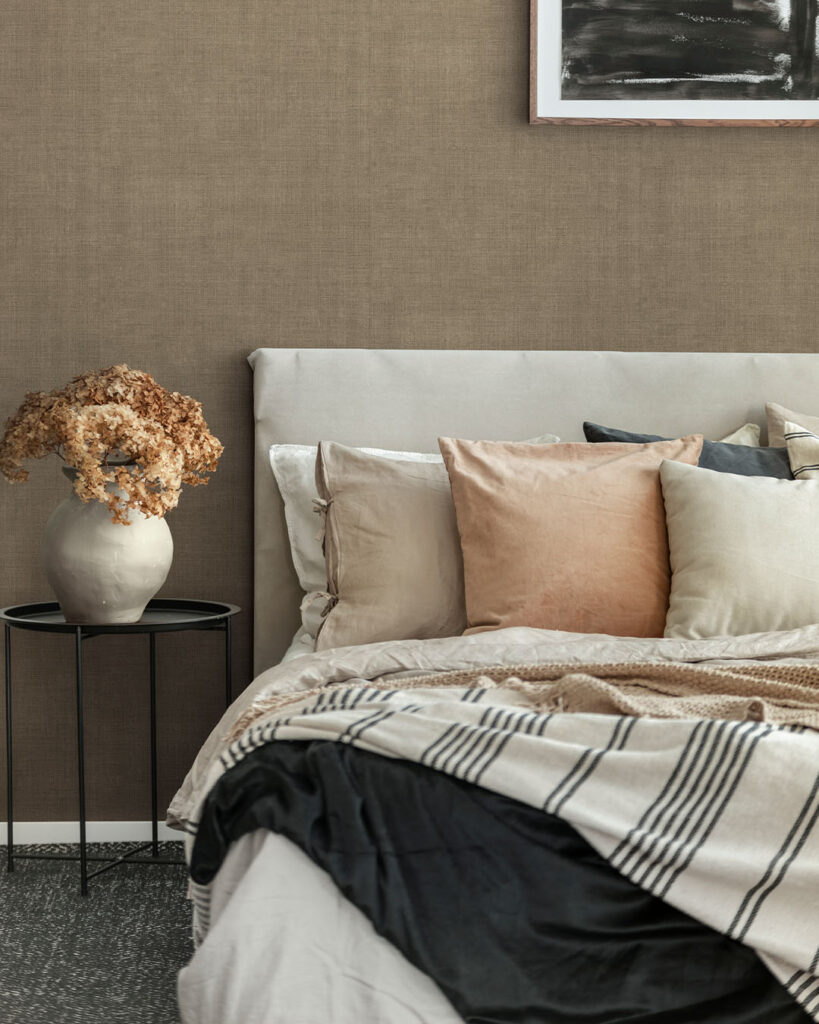 Brown linen wallpaper in the bedroom creates a cozy atmosphere.