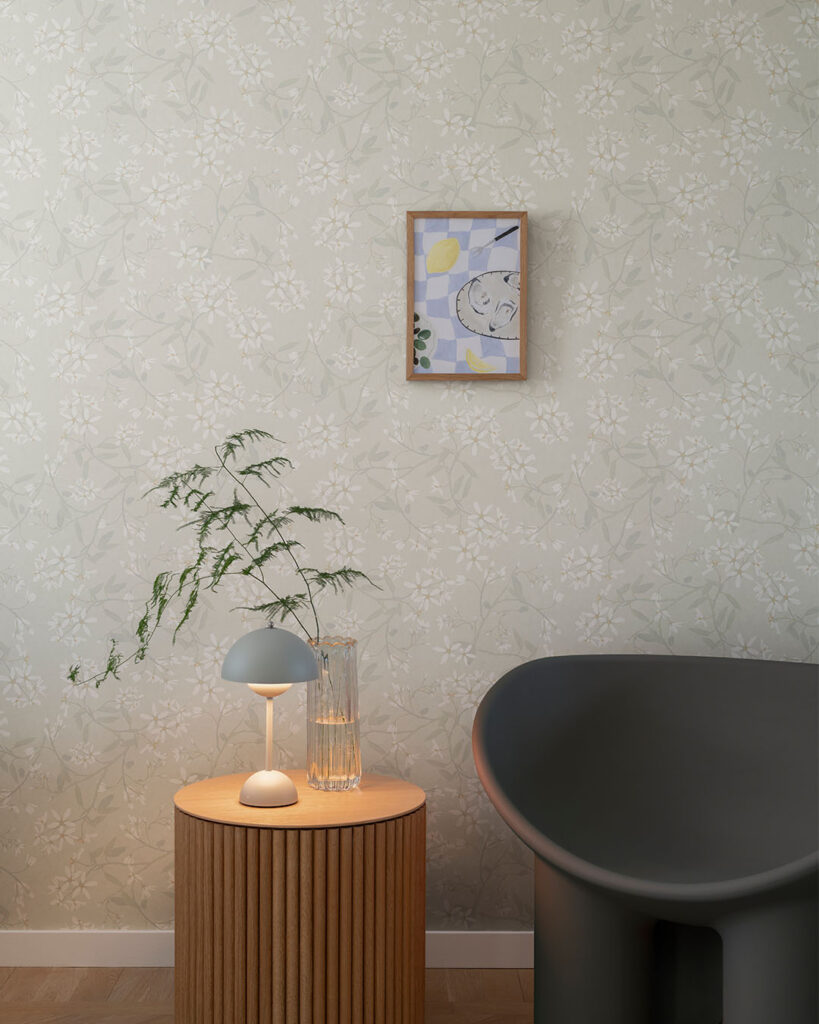 Beige tapet med blommor i en hall med en svart fåtölj