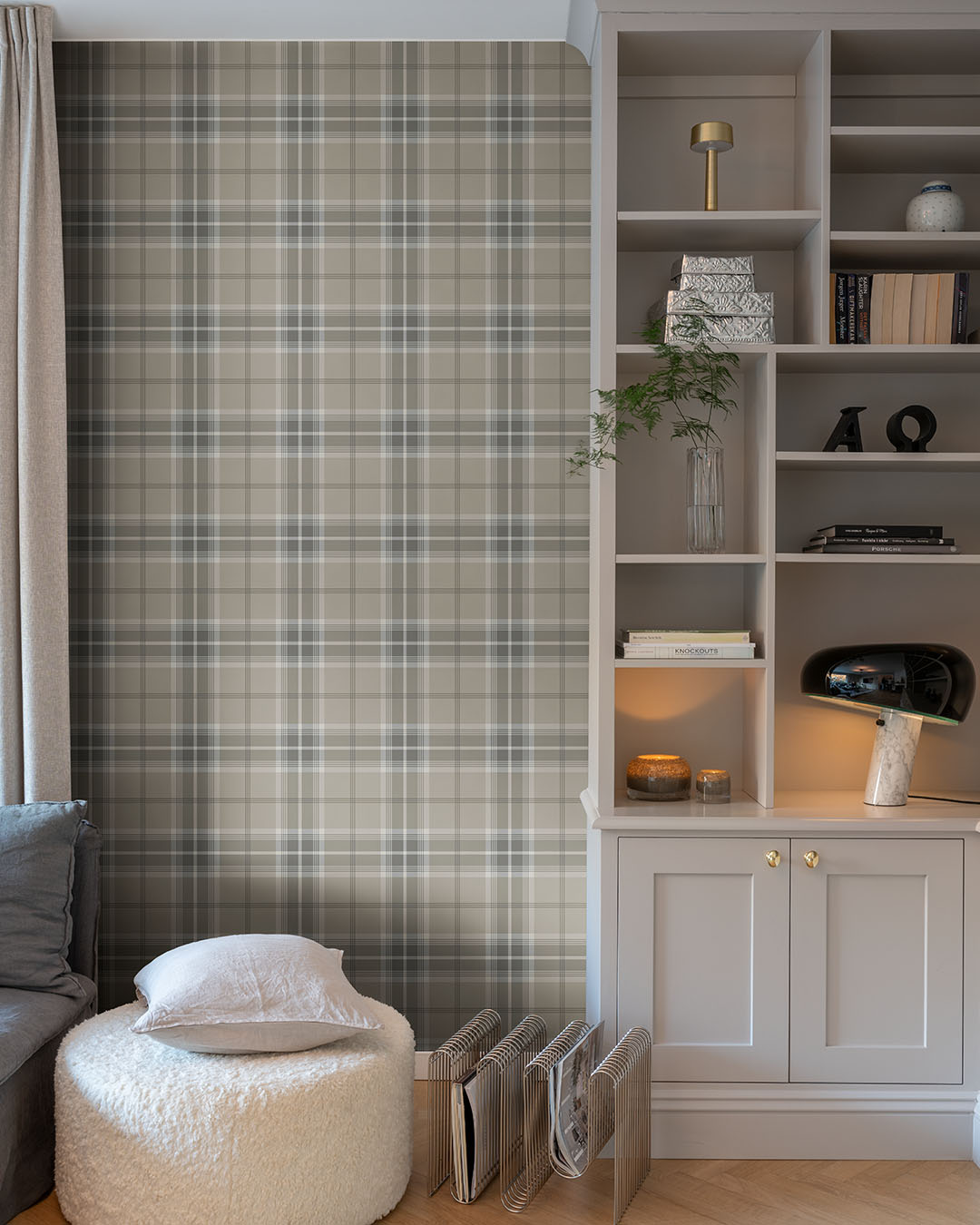Tapet med rutigt mönster i varierande beige kulörer i ett vardagsrum med en vit bokhylla