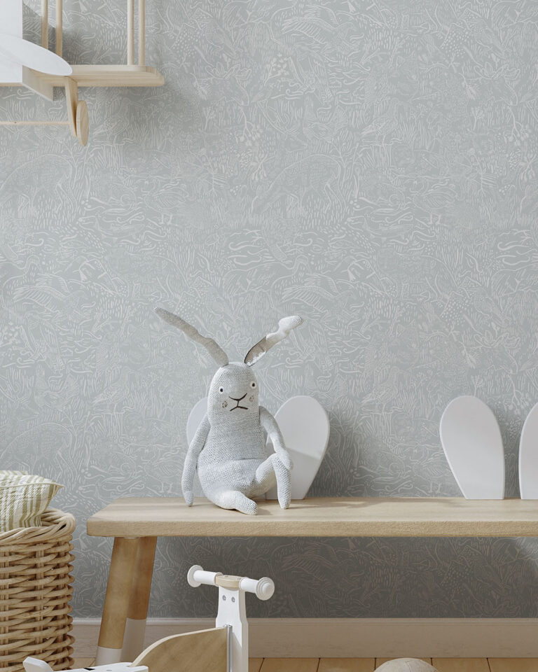 Light blue wallpaper with cartoon forest motifs in a child's room, featuring a stuffed animal on a bench