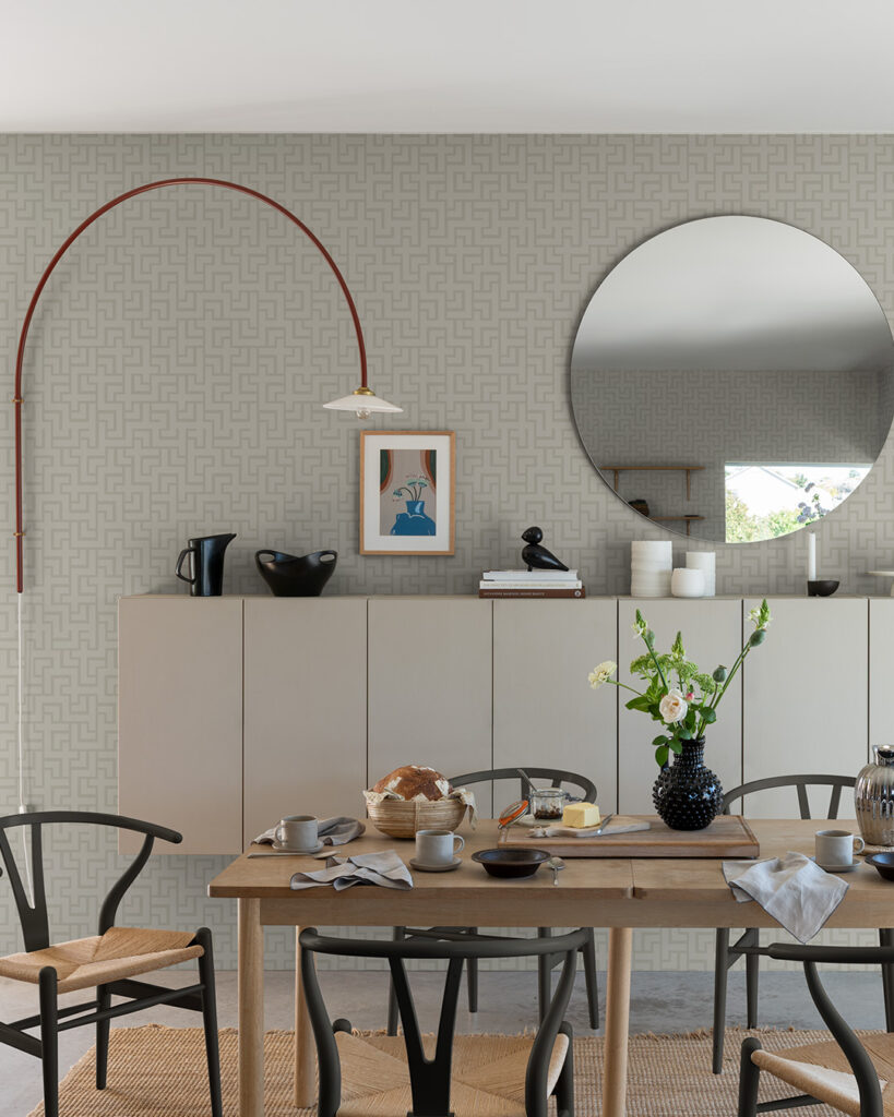 matsal med dukat bord, rund spegel på väggen och beige tapet