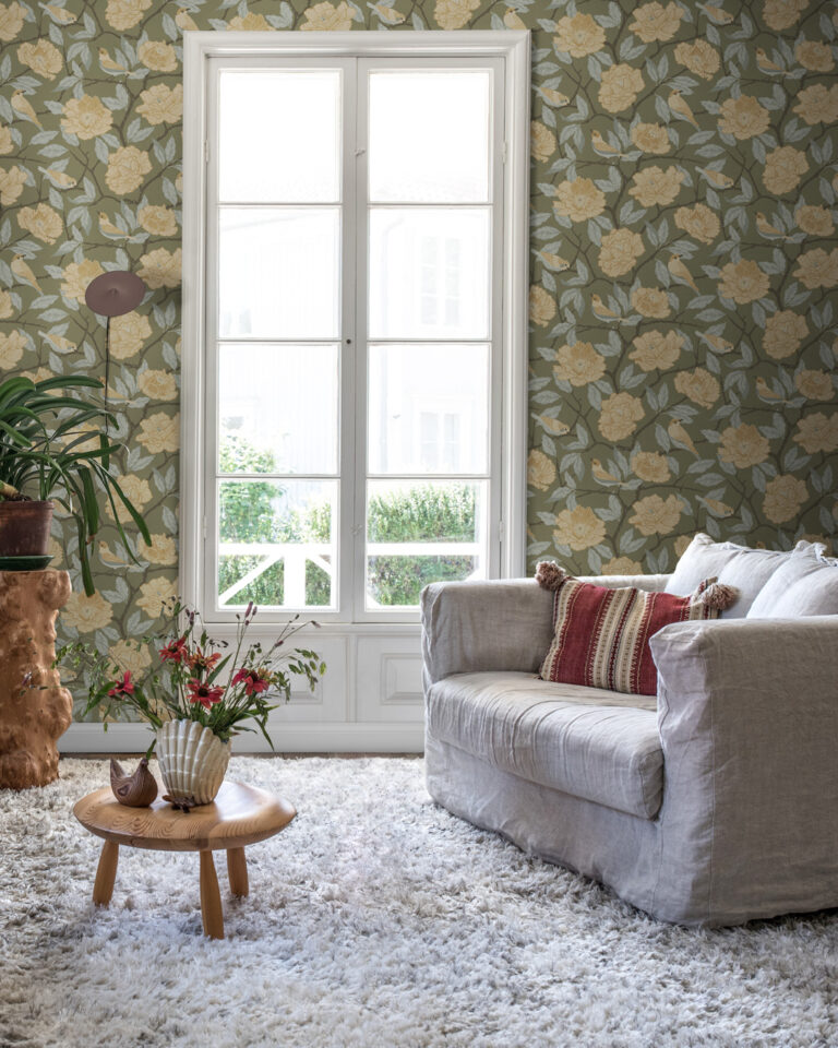 Green wallpaper with beige flowers and birds in a living room