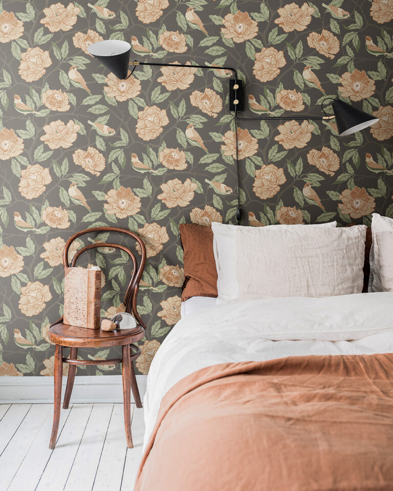 Mönstrad tapet med orange fåglar och blommor mot en svartbrun botten