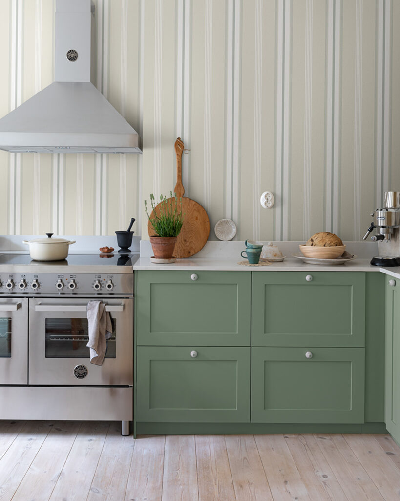 Beige striped wallpaper in a kitchen with green cabinet doors
