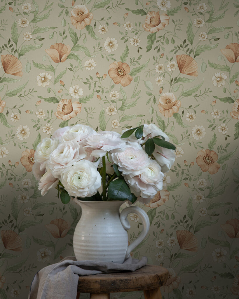 Floral wallpaper with a gray background and green leaves behind a bouquet of pale pink flowers