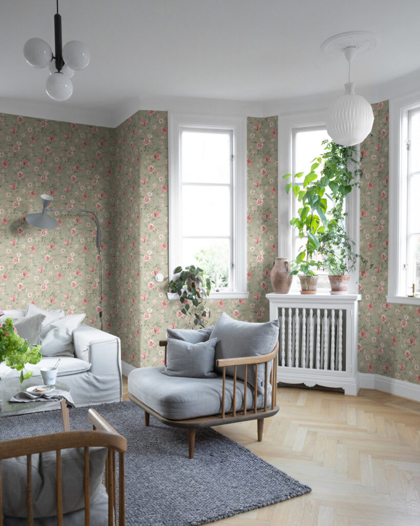 Grön tapet med rosa blommor i ett stilrent vardagsrum med gröna växter