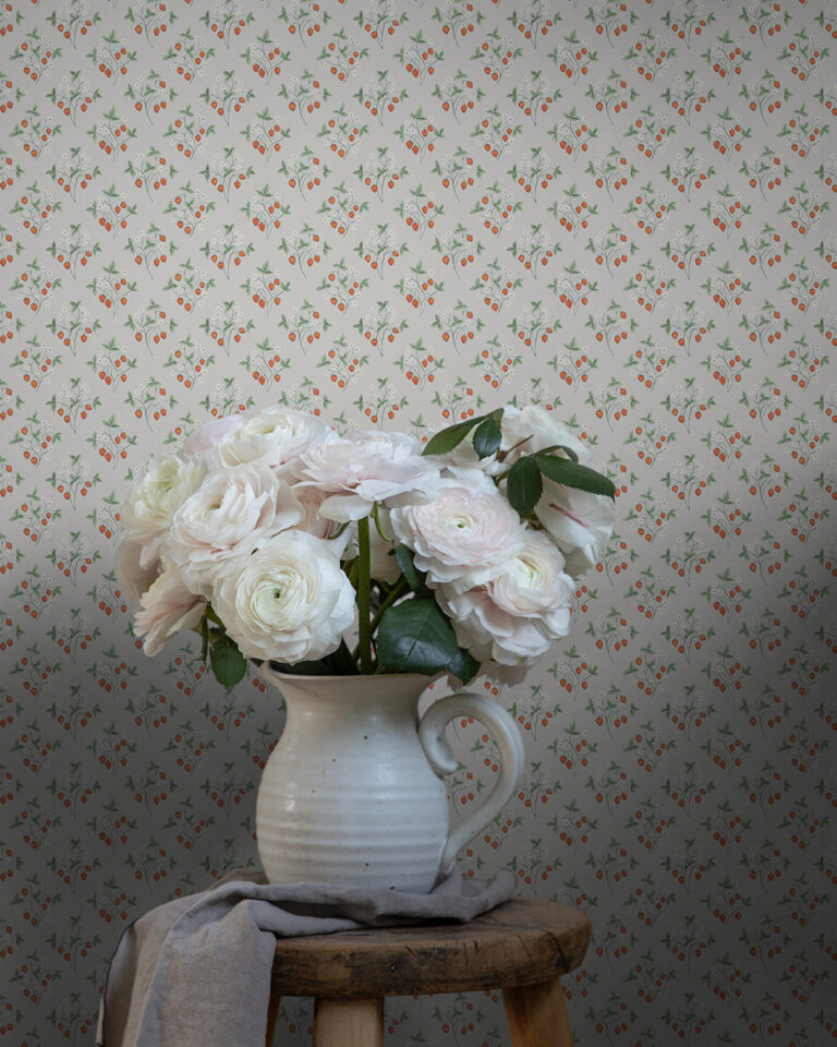 Greige small-flowered wallpaper featuring tiny strawberry plants behind a pot with beautiful pale pink flowers