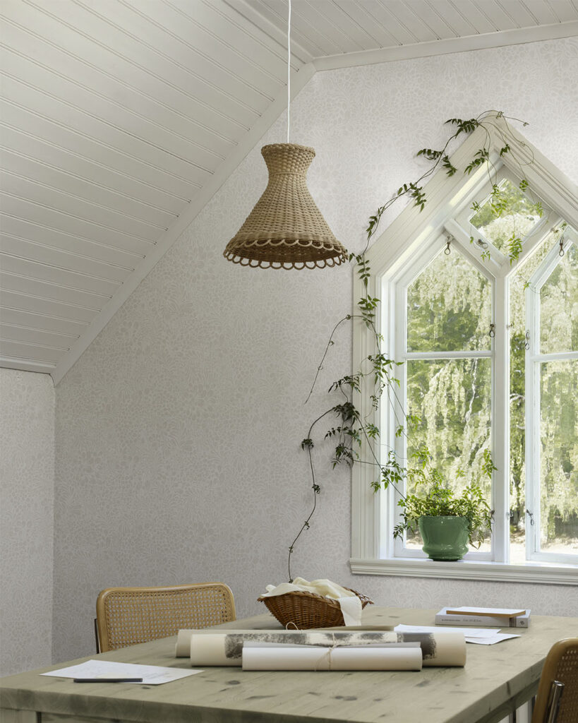 Vit blommig tapet i ett kontor med ett stort fönster