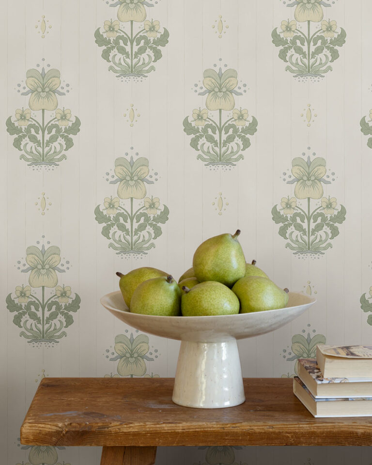 White wallpaper with flowers behind a bowl of pears in a hallway