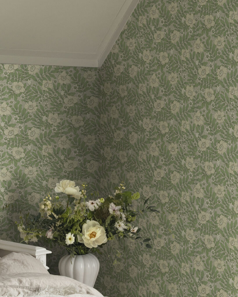 Green floral wallpaper with a gray background in a bedroom featuring a bouquet of flowers in a white vase