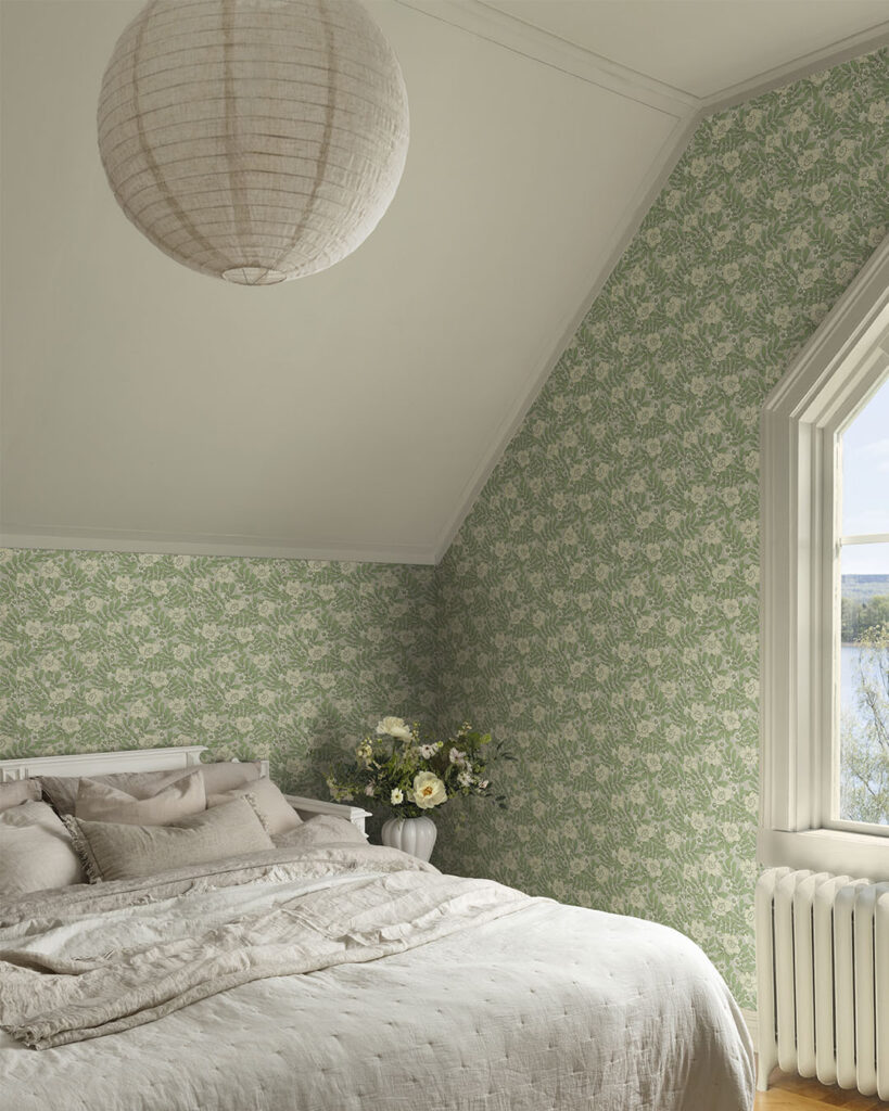 Green wallpaper with a gray background in a bedroom with a made bed and a large window