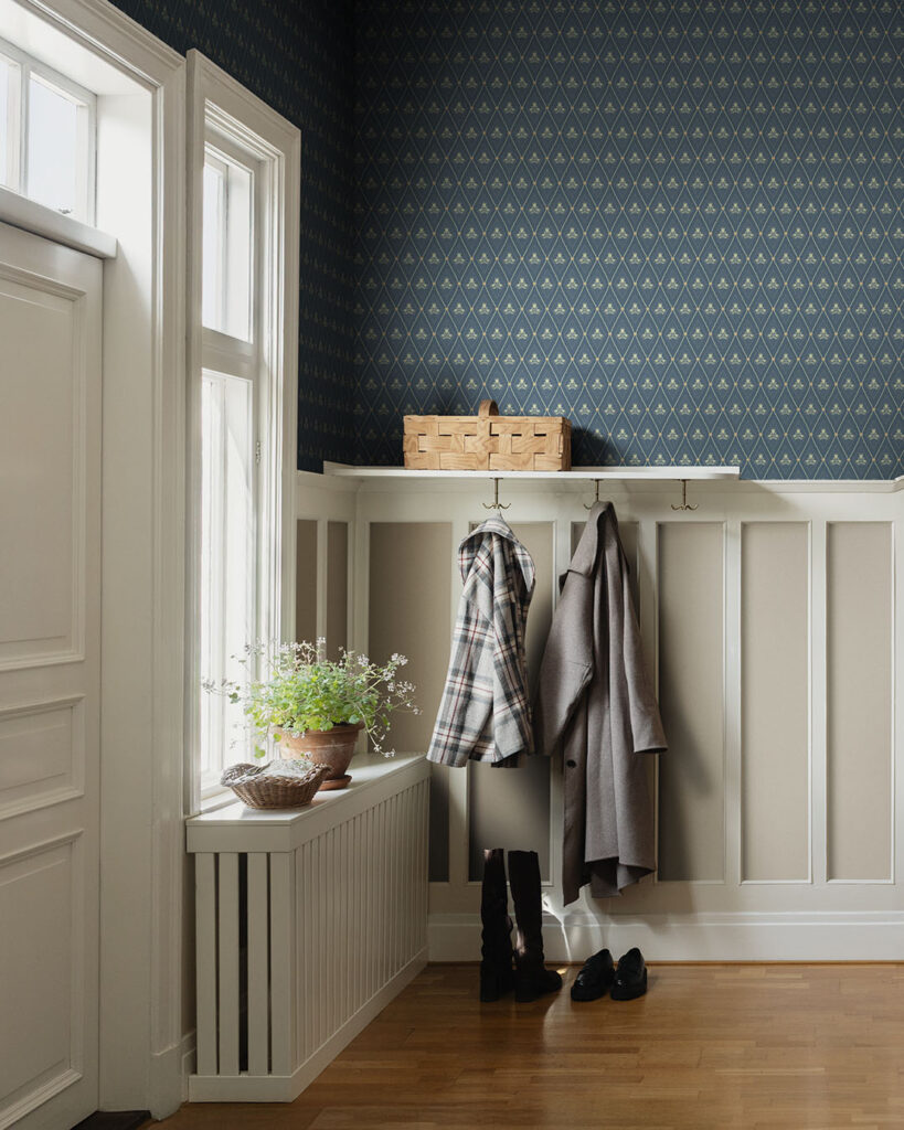 Blommig blå tapet i trellismönster i en hall med bröstpanel