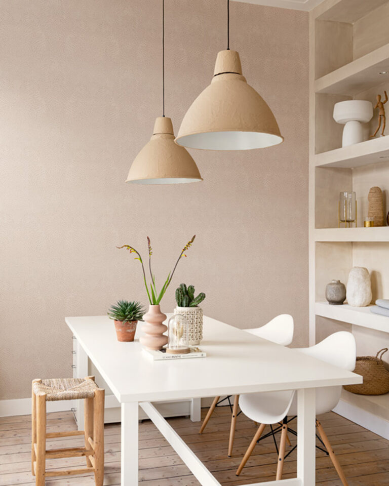 Beige wallpaper with a pearlescent effect in a dining room with a white table and a large bookshelf
