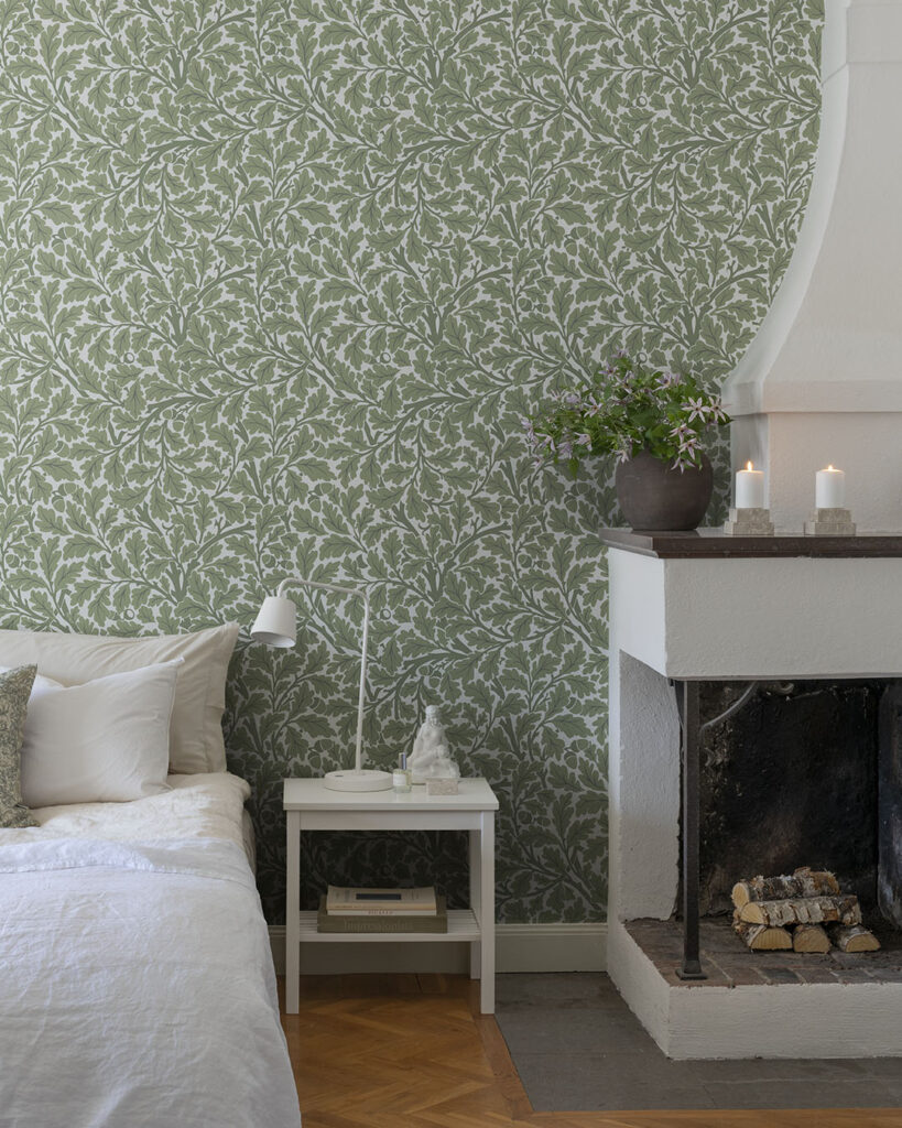 Grön tapet med blad (ekblad) i sovrum. Detta mönster heter Oak Tree och är designat av William Morris.