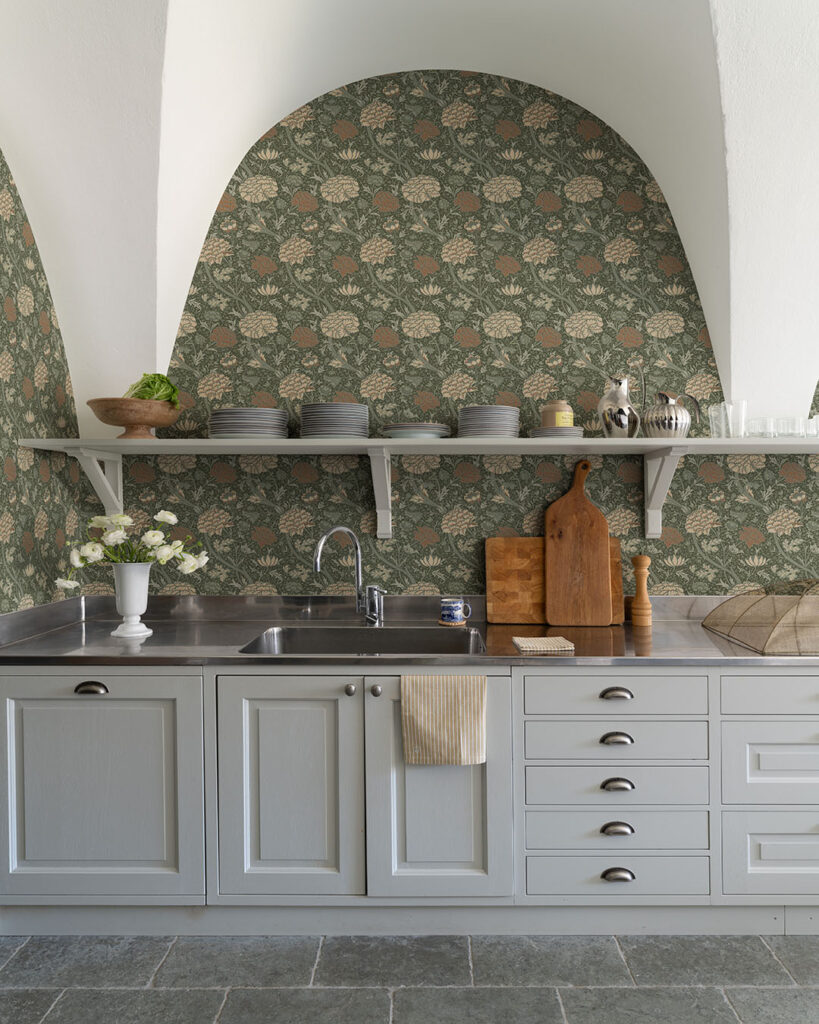Green wallpaper with flowers and leaves in a kitchen with gray cabinet doors