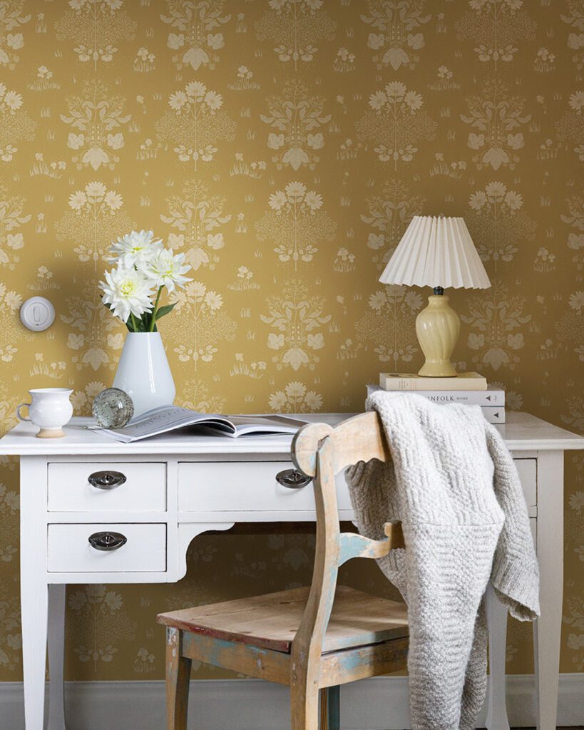 Yellow wallpaper with white flowers behind an old-fashioned white desk