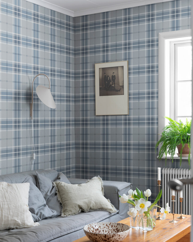 Blå rutig tapet i vardagsrum med grå soffa och soffbord i trä