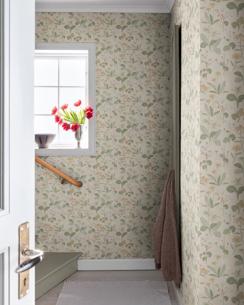 Light yellow floral wallpaper with green leaves in a hallway near a staircase